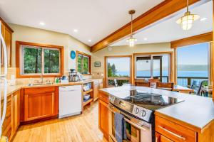 a kitchen with wooden cabinets and a view of the ocean at Tahuya Trees and Tides in Tahuya