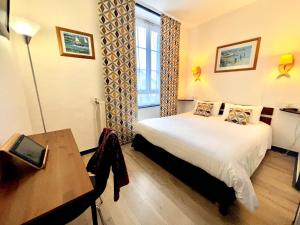 Ένα ή περισσότερα κρεβάτια σε δωμάτιο στο L'Hôtel de Loctudy