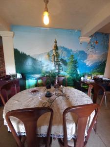 a dining room with a table and a mural at Lake Breeze in Nuwara Eliya