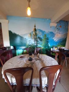 努沃勒埃利耶的住宿－Lake Breeze，一间带桌子和壁画的用餐室