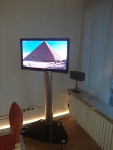 un televisor en un stand en una habitación con una pirámide en Weitblick, en Bad Harzburg