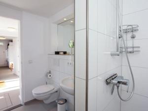 ein weißes Badezimmer mit Toilette und Dusche in der Unterkunft Zeelicht in Noordwijkerhout + 48 Fotos