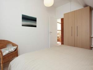 1 dormitorio blanco con 1 cama grande y armario en Zeelicht, en Noordwijkerhout