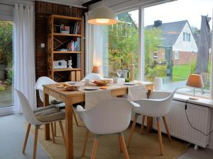 ein Esszimmer mit einem Tisch und weißen Stühlen in der Unterkunft Zeelicht in Noordwijkerhout