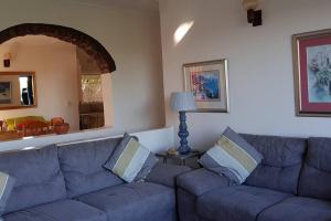 a living room with a blue couch and a lamp at On The Beach @ South Sands.No 2 in Port Edward