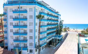 Big Blue Sky Hotel - All Inclusive في ألانيا: مبنى بشرفات زرقاء بجانب الشاطئ