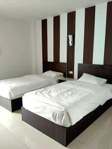 Een bed of bedden in een kamer bij โรงแรมวิจิตรพร อุบล VJP Hotel Ubon