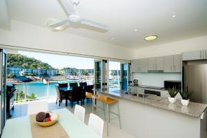 eine Küche und ein Esszimmer mit Blick auf das Wasser in der Unterkunft Beachside Magnetic Harbour Apartments in Nelly Bay