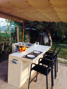 an outdoor kitchen with a table and chairs under a tent at Los Olivos Villa in Sanlúcar de Barrameda
