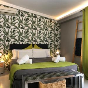 a bedroom with a green bed with a black and white wallpaper at Atico Atalaya in Alicante