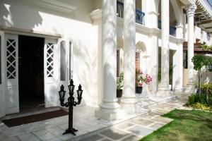 a white house with columns and a courtyard at Dileep Kothi - A Royal Boutique Luxury Suites in Jaipur in Jaipur