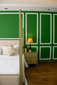 1 dormitorio con 1 cama con pared verde en Dileep Kothi - A Royal Boutique Luxury Suites in Jaipur en Jaipur