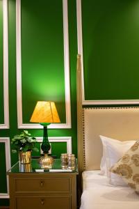 a green bedroom with a bed and a lamp on a night stand at Dileep Kothi - A Royal Boutique Luxury Suites in Jaipur in Jaipur