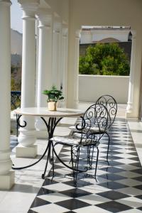 d'une terrasse couverte avec une table et deux chaises. dans l'établissement Dileep Kothi - A Royal Boutique Luxury Suites in Jaipur, à Jaipur