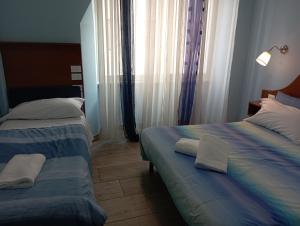 um quarto de hotel com duas camas e uma janela em NEW PARADISE em Roma