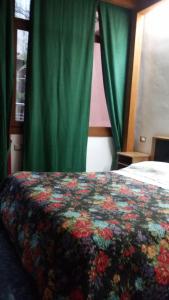 a bedroom with a bed with a floral blanket on it at B&B La Salghè in Argenta