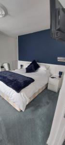 a bedroom with a large bed with a blue wall at Sycamore House in Laurière