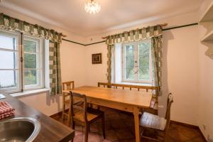 - une salle à manger avec une table en bois et un lavabo dans l'établissement Ferienwohnung Försterstüberl, à Seeshaupt