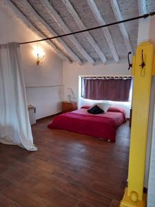 1 dormitorio con cama roja y ventana en La Gata Mala en Navarrés