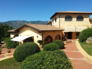 a large house with a walkway in front of it at Hotel Giardino Corte Rubja in Iglesias