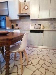 uma cozinha com uma mesa de madeira e armários brancos em B&B Sotto le Mura em Bérgamo