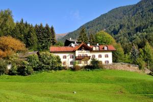a large house on a hill in a green field at Bad Burgstall App Gromml in SantʼAndrea in Monte