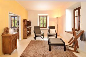 a living room with two chairs and a table at Bad Burgstall App Gromml in SantʼAndrea in Monte