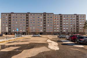 a parking lot with cars parked in front of a large building at Apartments Borg Wellamo in Pori