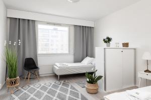 a white room with a bed and a window at Apartments Borg Wellamo in Pori