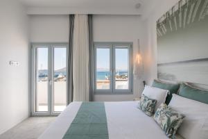 a bedroom with a bed with a view of the ocean at Anamnesia boutique apartments Naxos town in Naxos Chora