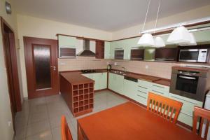 a kitchen with a wooden table and a kitchen with white appliances at Apartmán U krále - 1 in Jičín