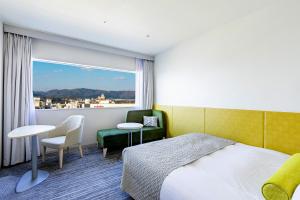 a hotel room with a bed and a window at Hotel Nikko Himeji in Himeji