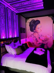 een kamer met een bed met een poster van een vrouw bij Loveroom romantique et insolite avec jacuzzi proche de Toulouse 
