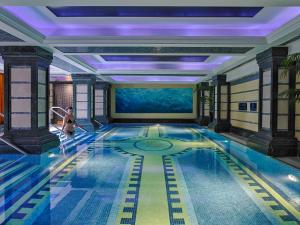 una piscina in un hotel con una donna che ci cammina dentro di Killarney Plaza Hotel & Spa a Killarney