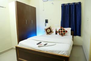 a bedroom with a bed with a blue curtain at Lakeview Residency, Sricity TADA in Tada