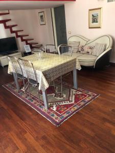 una mesa con sillas y un sofá en la sala de estar. en Zappala' Gemelli House, en Catania