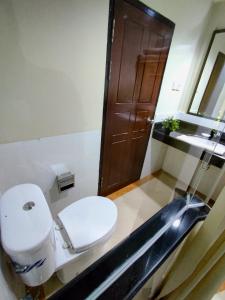 a bathroom with a toilet and a sink at Crystal City Hotel in Mataram