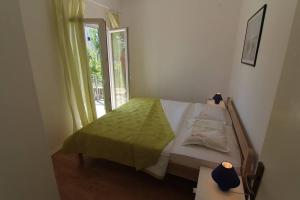 a small bedroom with a bed and a window at Apartments Zora in Pirovac