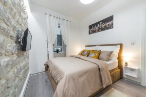 1 dormitorio con cama y pared de piedra en Apartment 16 steps en Dubrovnik