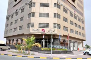 a building with a car parked in front of it at Ewan Ajman Suites Hotel in Ajman 