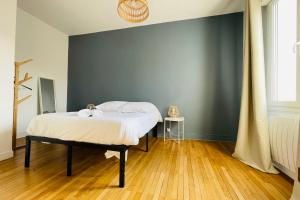 a bedroom with a bed and a blue wall at The Timeless - Balzacien in Tours
