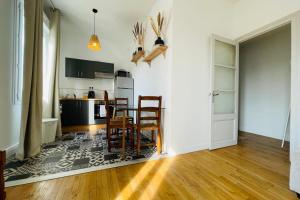 a kitchen with a table and chairs in a room at The Timeless - Balzacien in Tours +8 photos