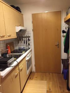 a kitchen with a sink and a wooden door at Nido Alpino Fiescheralp in Fiesch +19 photos