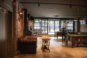 a woman playing pool in a room with a pool table at Fountain Hotel in London