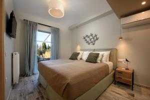 Un dormitorio con una cama grande y una ventana en Efilenia Luxury Villas en Corfú
