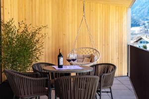 a table with a glass of wine and some chairs at Adler Living Attika Wohnung in Naturno +19 photos