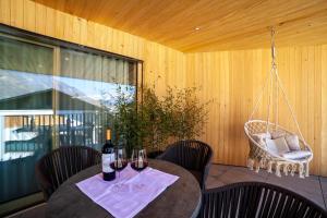 a table with two glasses of wine and a chair at Adler Living Attika Wohnung in Naturno