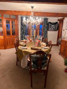 a dining room with a table and a chandelier at Stunning location on Pendle Hill in Nelson
