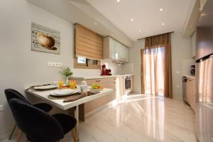 a kitchen with a table and chairs in a room at Efilenia Luxury Villas in Corfu Town