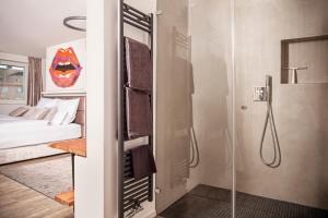 a bathroom with a shower and a bedroom with a bed at The Faces Berlin in Berlin